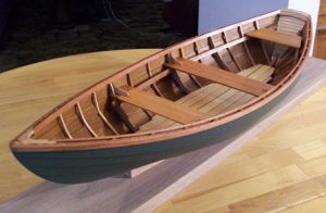 Varnished wooden rowboat with seats and ribs