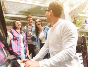 Friends singing along while a man plays the piano