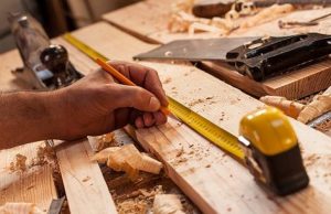Measuring and marking a board with a tape measure and a pencil